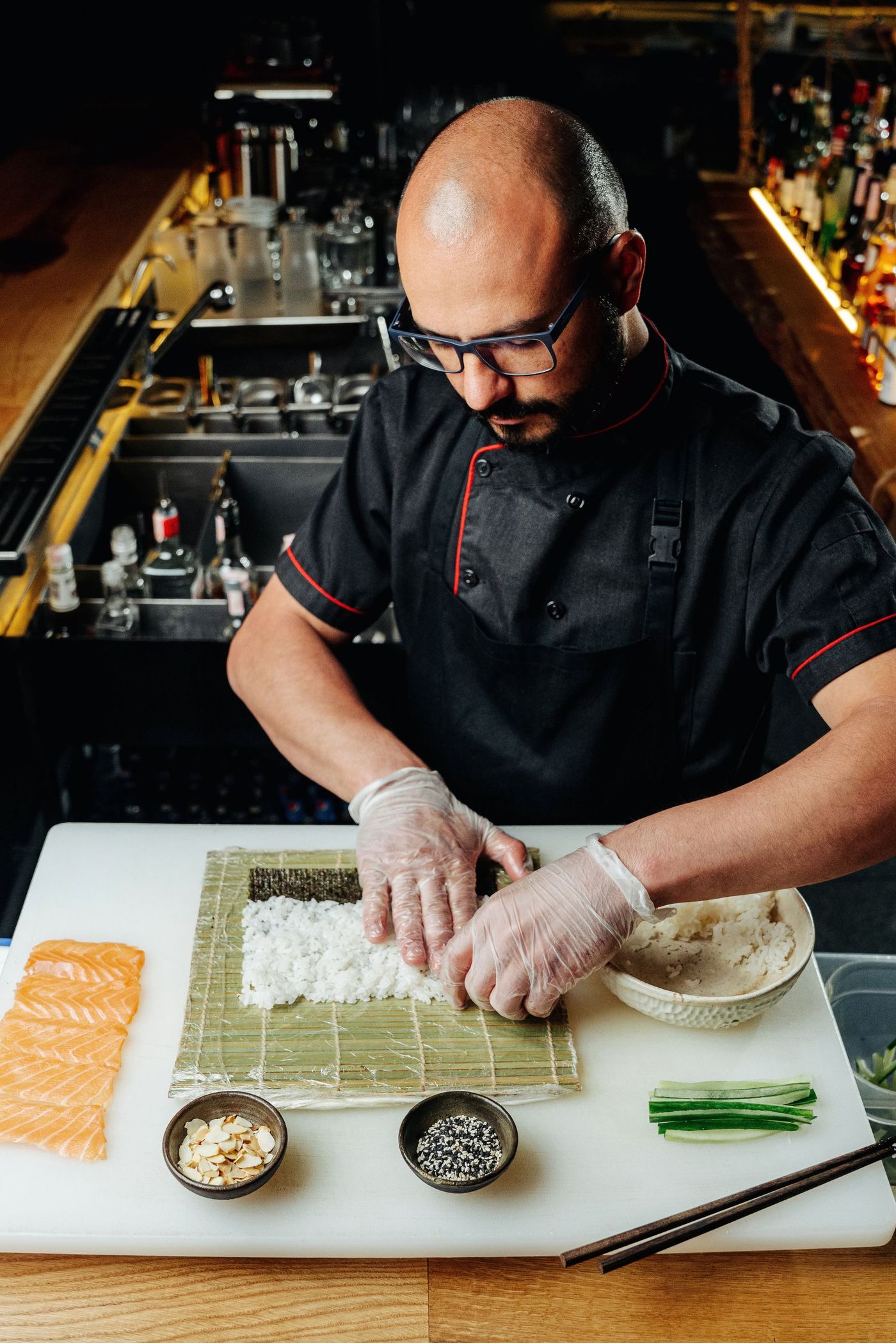 A sushi chef rolling sushi